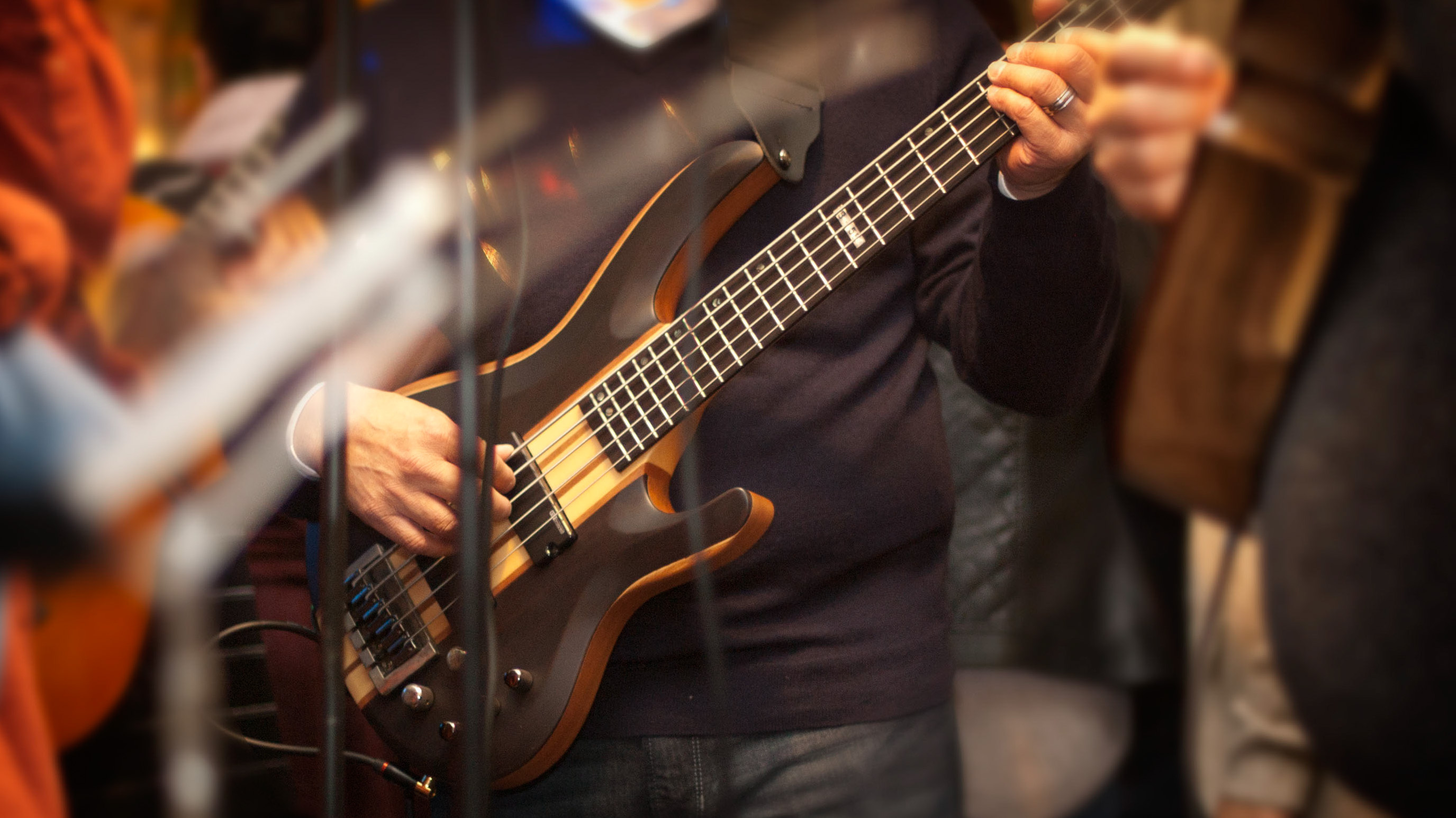A guy playing a 5 string bass