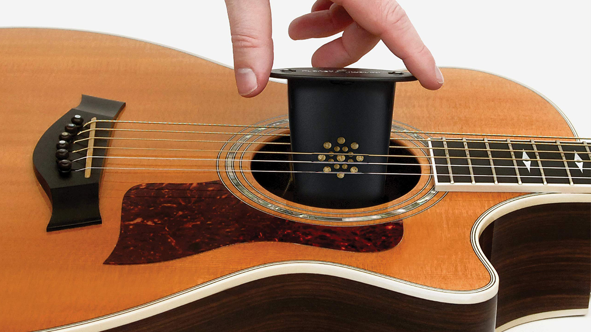 Hand putting humidifier in guitar